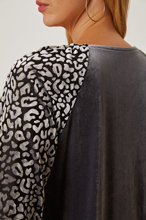 Velvet raglan top in dark gray with black and silver leopard print sleeves.