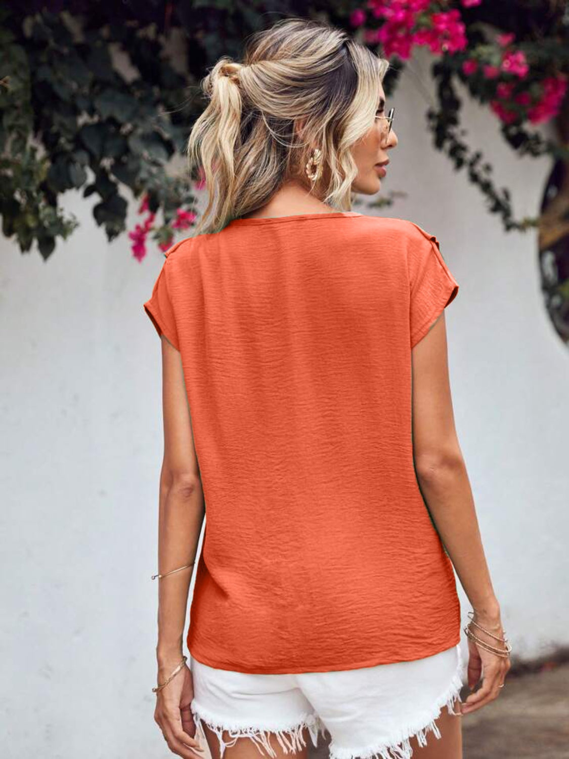 Orange-red textured V-neck flutter sleeve blouse with a casual fit.