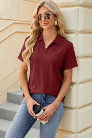 Burgundy textured polo shirt with V-neck detail and short sleeves.