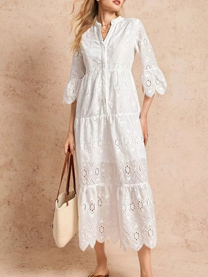 White eyelet midi dress with tiered skirt, button front, and ruffled sleeves.