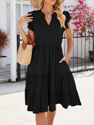 Black ruffled midi dress with notched V-neck and tiered skirt.