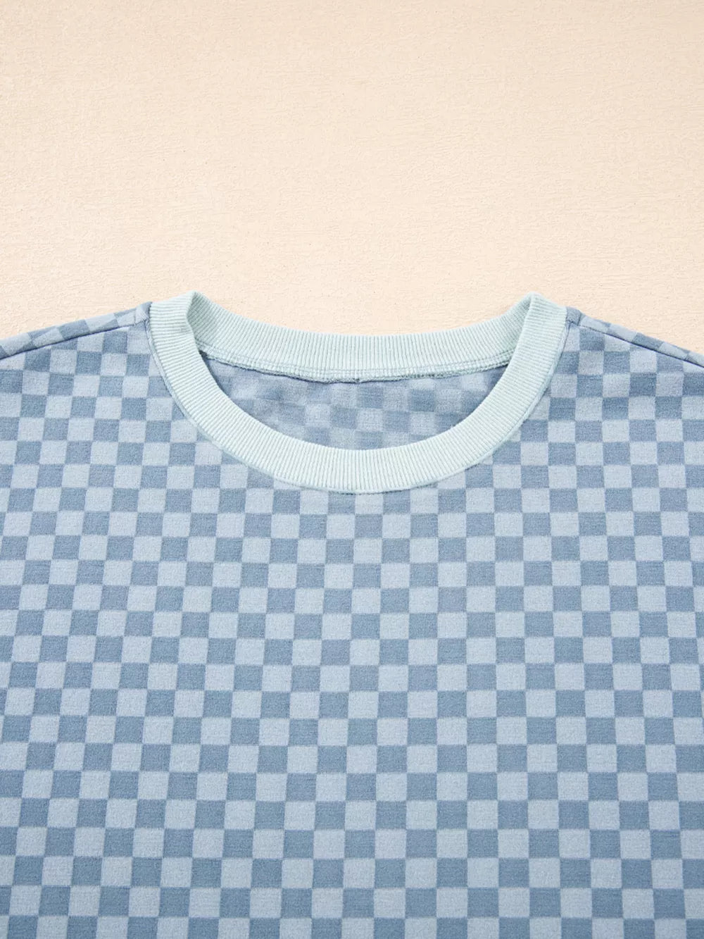 Light blue checkerboard loungewear pullover with crew neck and contrast trim.