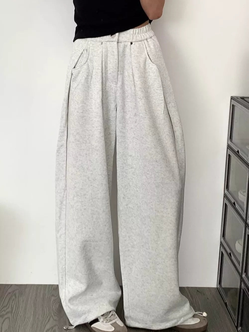 Men's gray wide-leg sweatpants with adjustable drawstring hem and pockets.