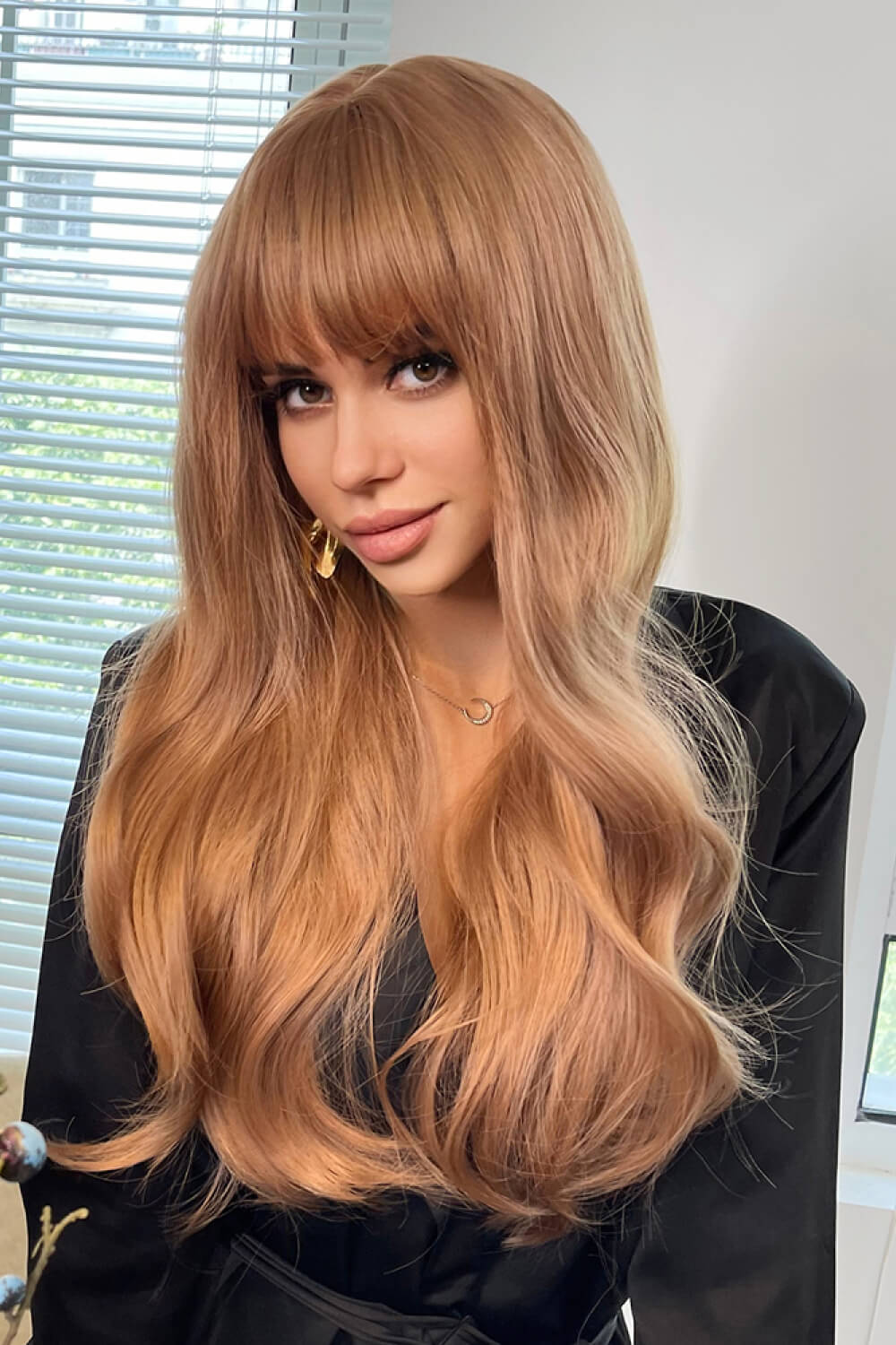 Strawberry blonde wig with bangs and sunset waves, styled casually.