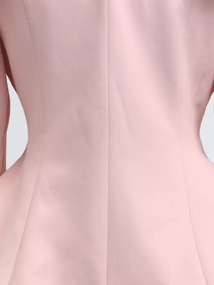 Pink skirt suit with balloon sleeves and a frill collar detail.