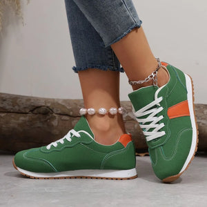 Green suede and canvas sneakers with orange accents and white laces.