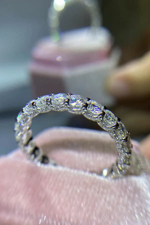 Silver moissanite eternity band ring with brilliant cut stones.