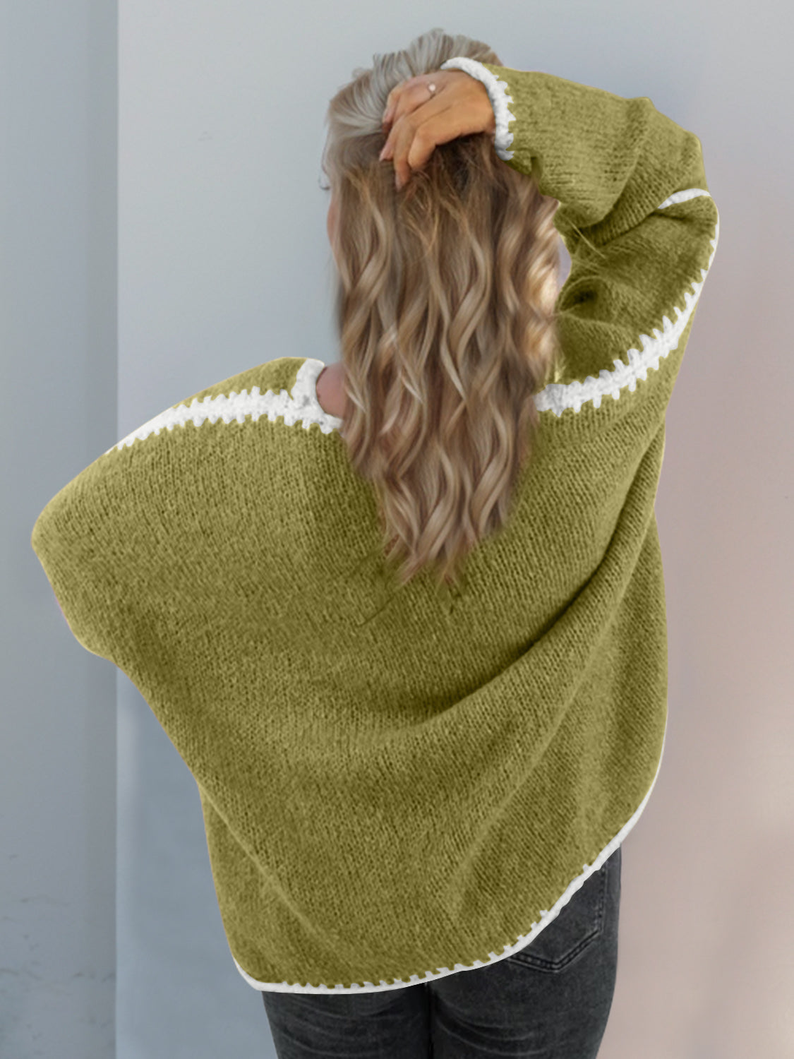 Oversized knit cardigan in Yellow-Green with white contrast stitching on the sleeves and hem.