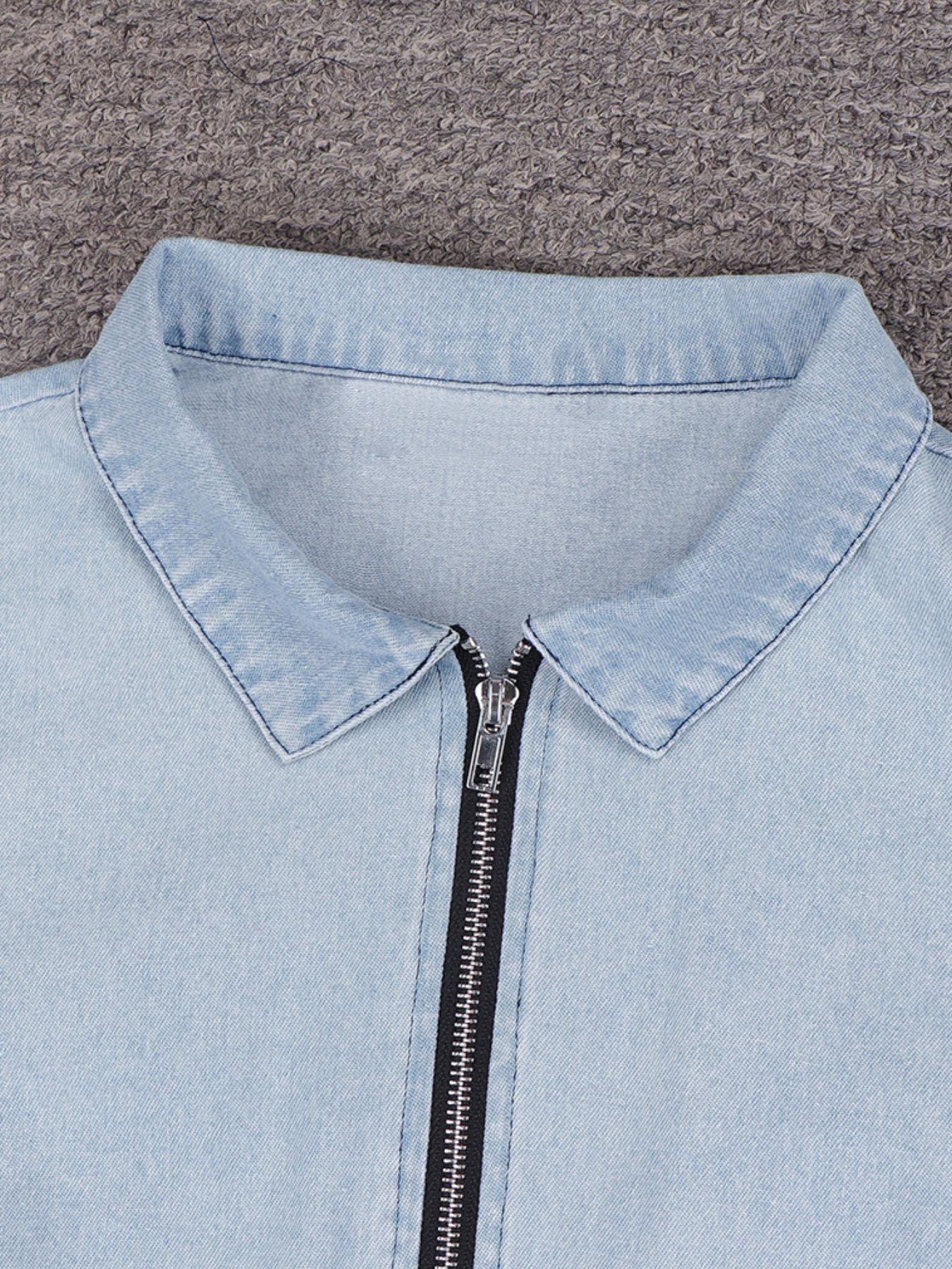 Light wash denim mini dress with collared neckline and front zipper detail.