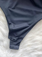 Black ruffled V-neck bodysuit with lace detail and snap closure