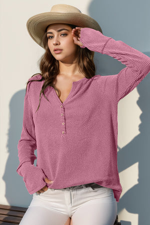 Pink waffle knit henley shirt with button placket and thumbhole cuffs.
