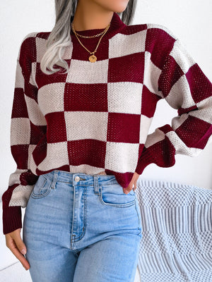 Checkerboard knit mock neck pullover sweater in burgundy and cream with open knit detail.