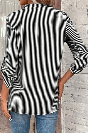Black and white vertical stripe V-neck blouse with roll-tab sleeves.
