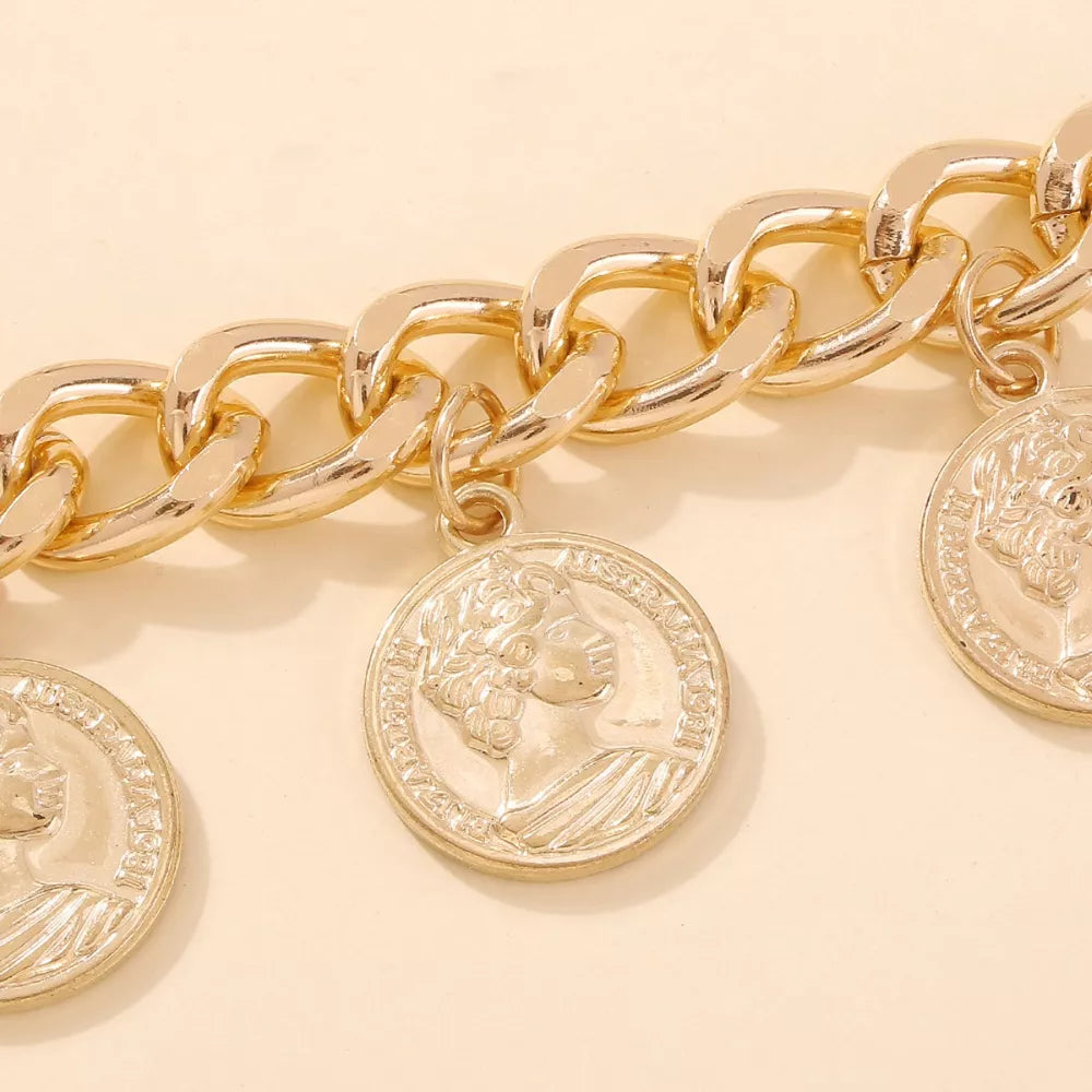 Chunky gold-plated chain bracelet with coin charms featuring a profile design.
