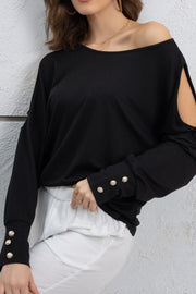 Black shoulder-slit top with button cuffs and a boat neckline.