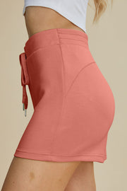 Coral scuba drawstring sport shorts with a textured waistband and metal-tipped ties.