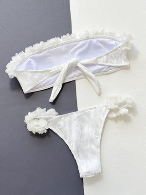 White textured bandeau bikini set with ruffle trim and floral applique details.