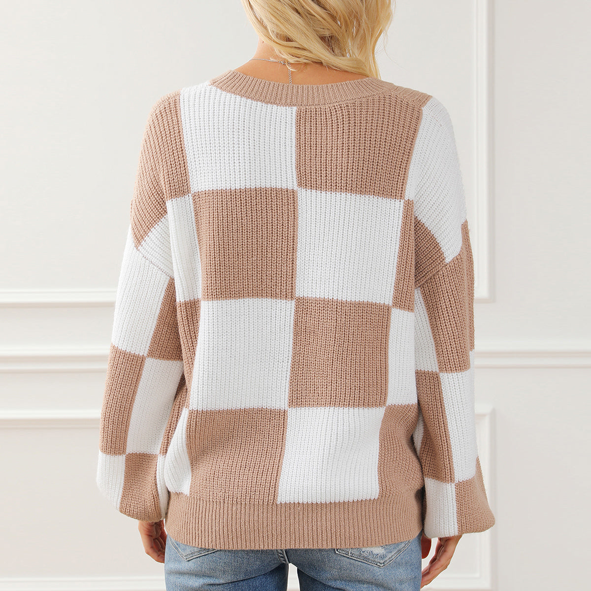 Checkerboard knit drop shoulder pullover sweater in tan and white acrylic with a crew neck.