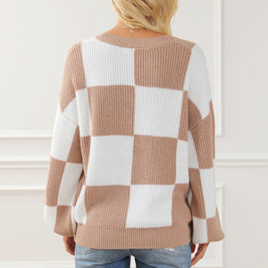 Checkerboard knit drop shoulder pullover sweater in tan and white acrylic with a crew neck.