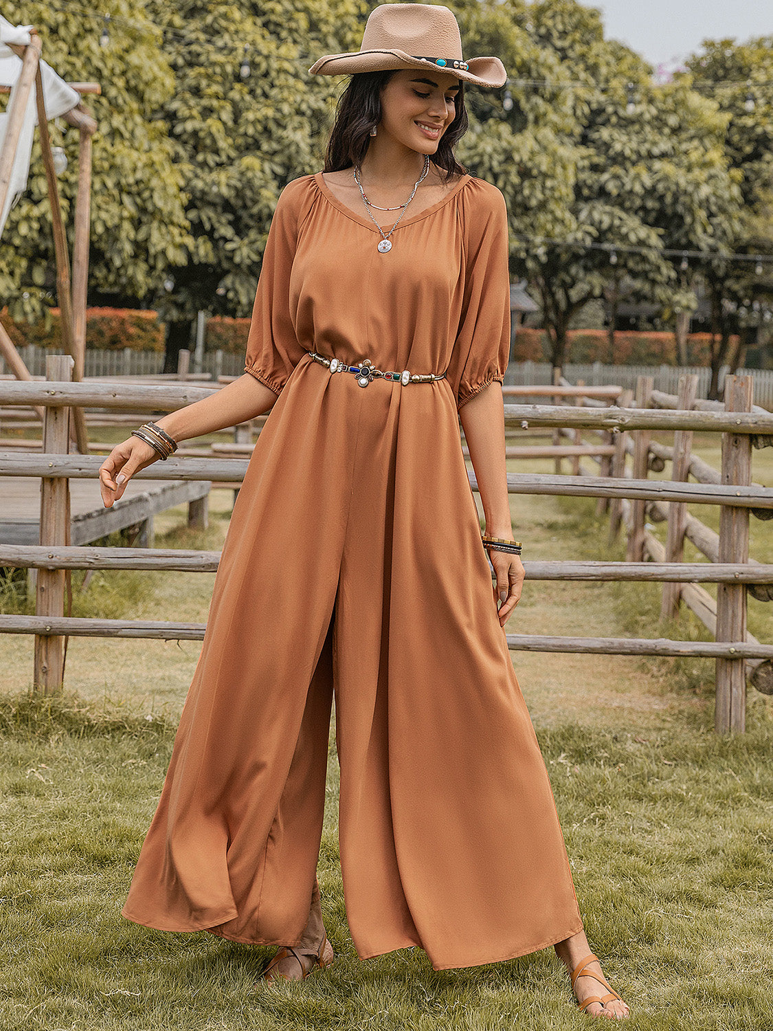 Caramel gathered sleeve wide-leg jumpsuit with a decorative belt and split legs.