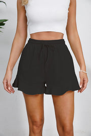 Black linen blend shorts with drawstring waist and flounce hem.