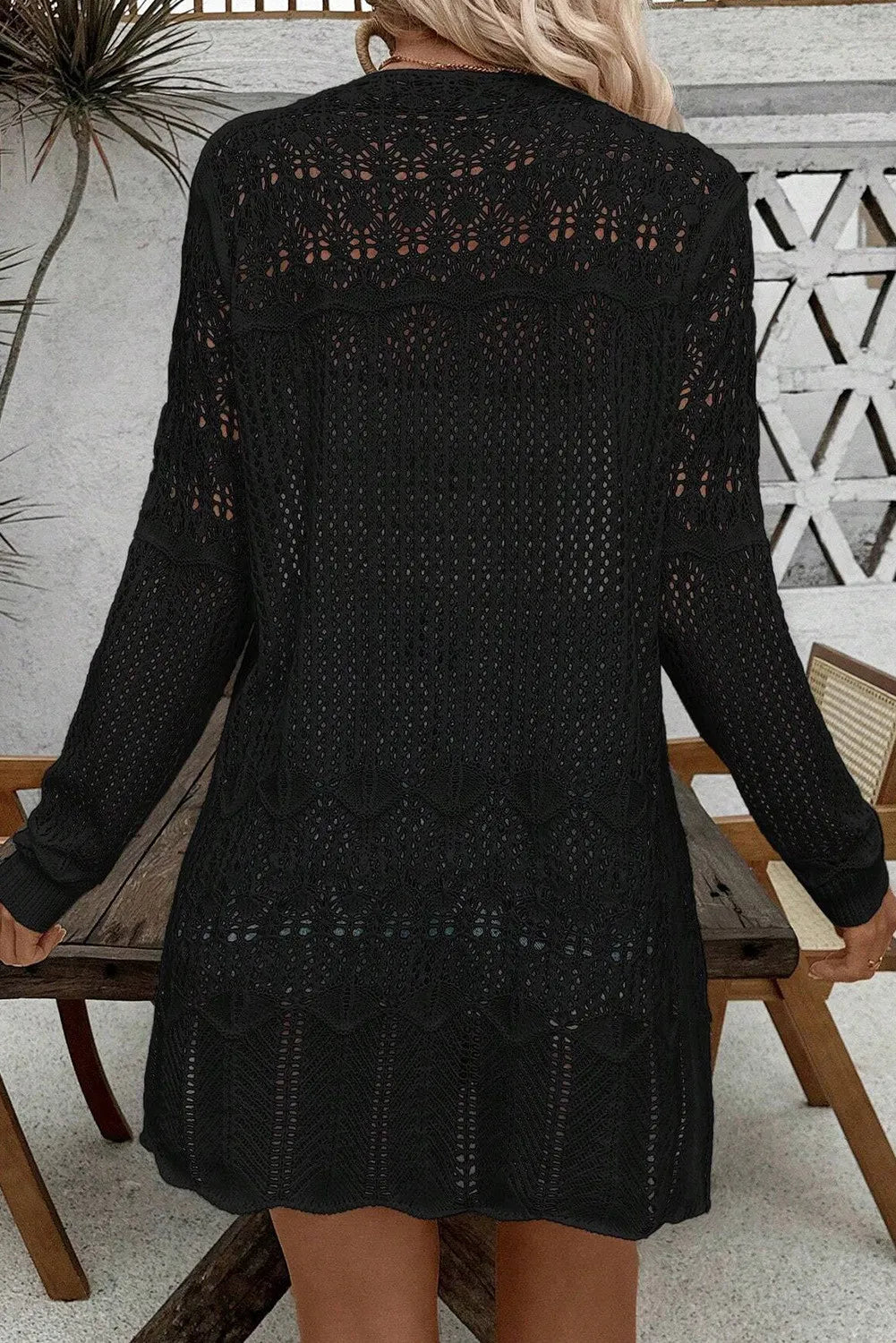 Black openwork crochet duster cardigan with long sleeves and intricate patterns.