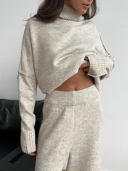 Oversized beige turtleneck lounge knit set with wide leg pants and ribbed cuffs.