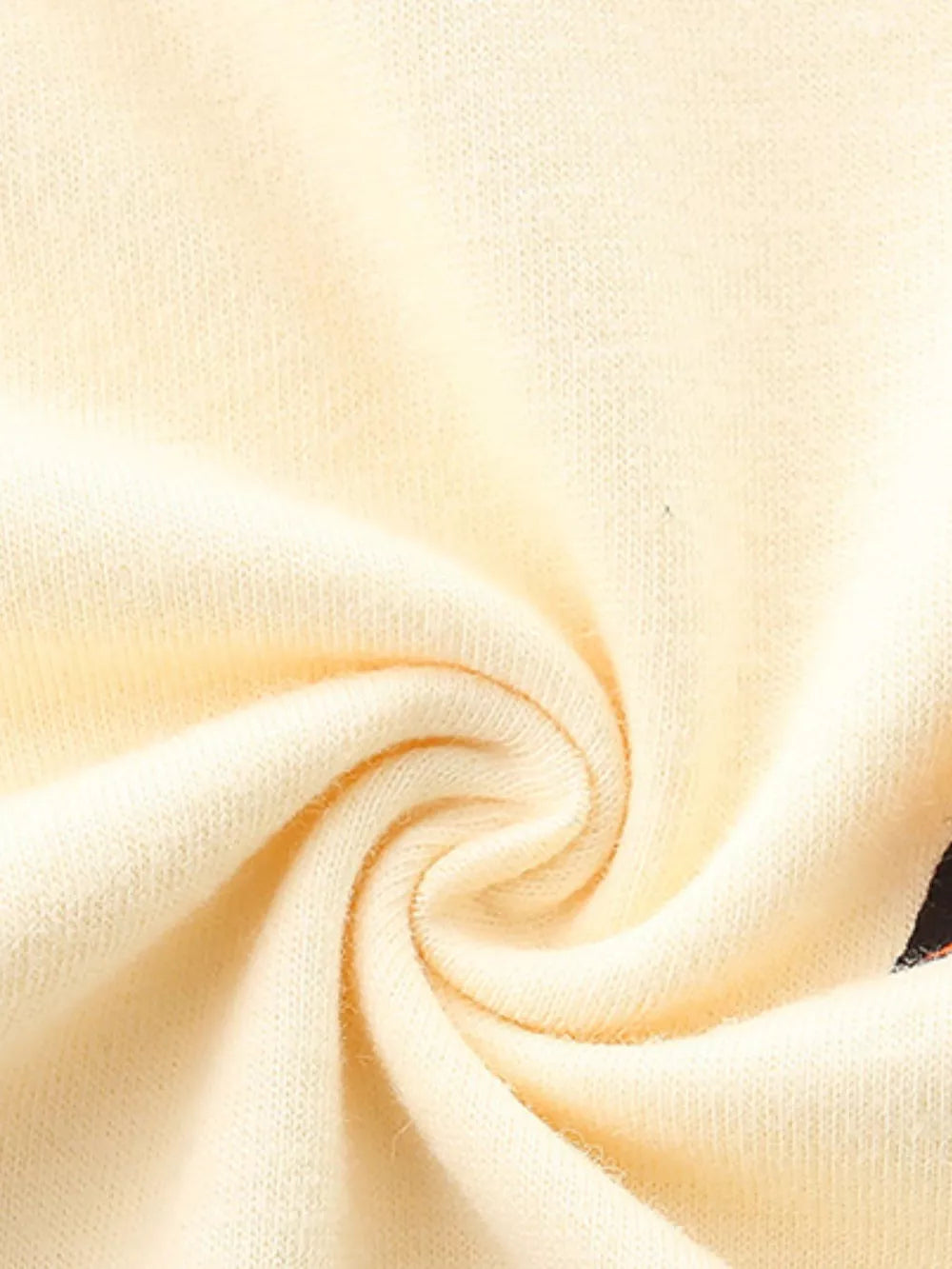 Cream cotton t-shirt fabric detail with a hint of a colorful racing car graphic.