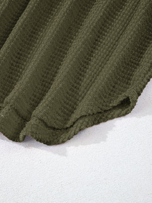 Moss green waffle-knit collared shirt with button detail and textured fabric.