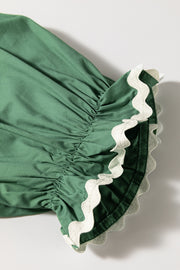 Moss green blouse with ruched puff sleeves and white scalloped trim detail.