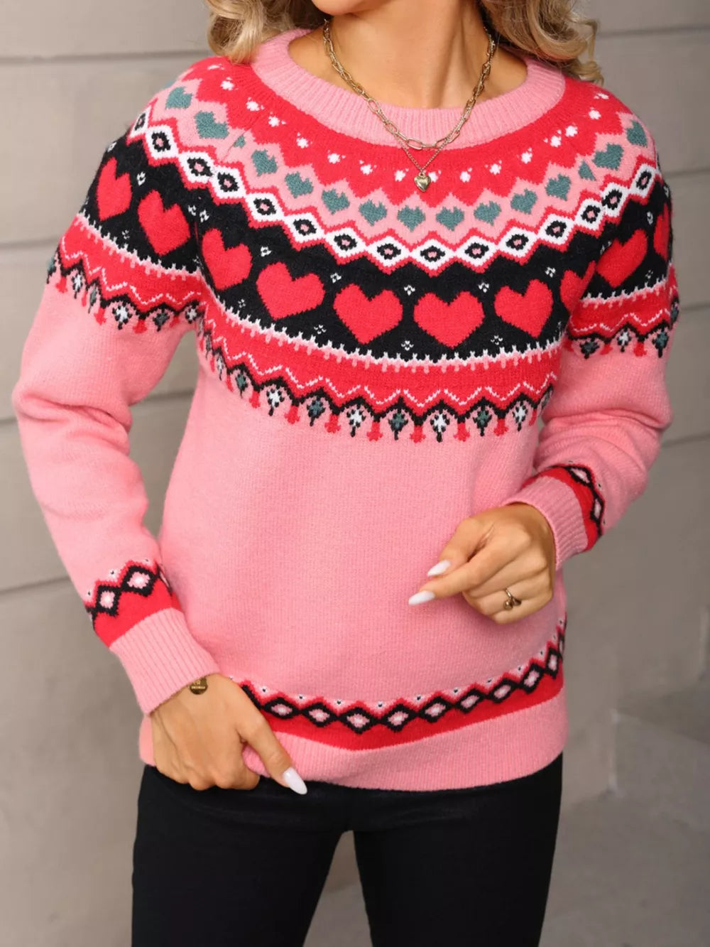 Pink acrylic crew neck sweater with festive heart motif and fair isle pattern.