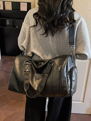 Black pu leather duffel bag with zippered pockets and embossed detail.