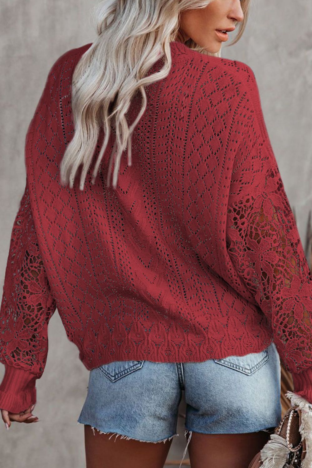 Red openwork knit sweater with lace sleeves and diamond pattern.