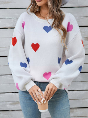 White acrylic knit sweater with colorful heart motif and bubble sleeves.