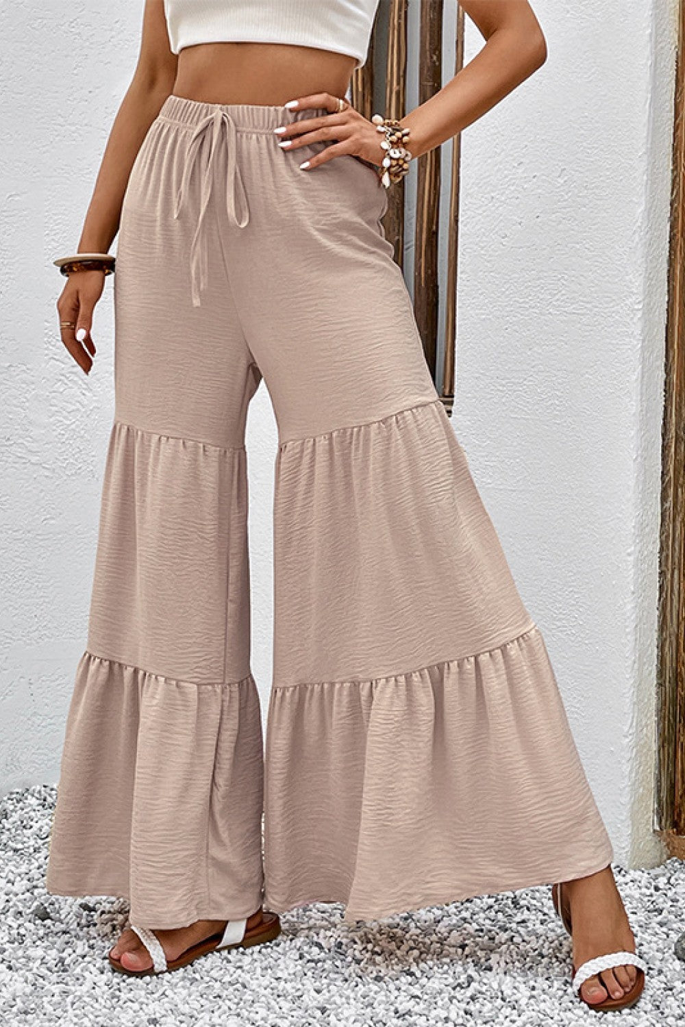 Tiered ruffle palazzo trousers in tan with a drawstring waist and wide leg.