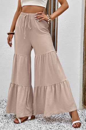 Tiered ruffle palazzo trousers in tan with a drawstring waist and wide leg.