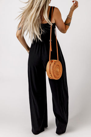 Black smocked square neck wide leg jumpsuit with a straw crossbody bag.