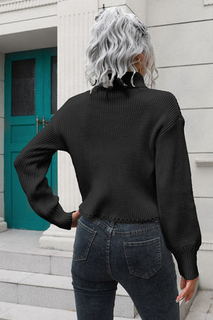 Black ribbed turtleneck sweater with scalloped hem and balloon sleeves.