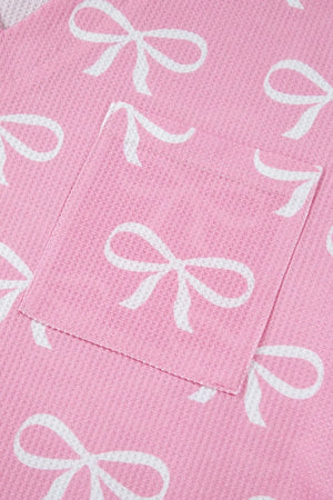 Pink ribbed loungewear set with white bow print and a chest pocket detail.
