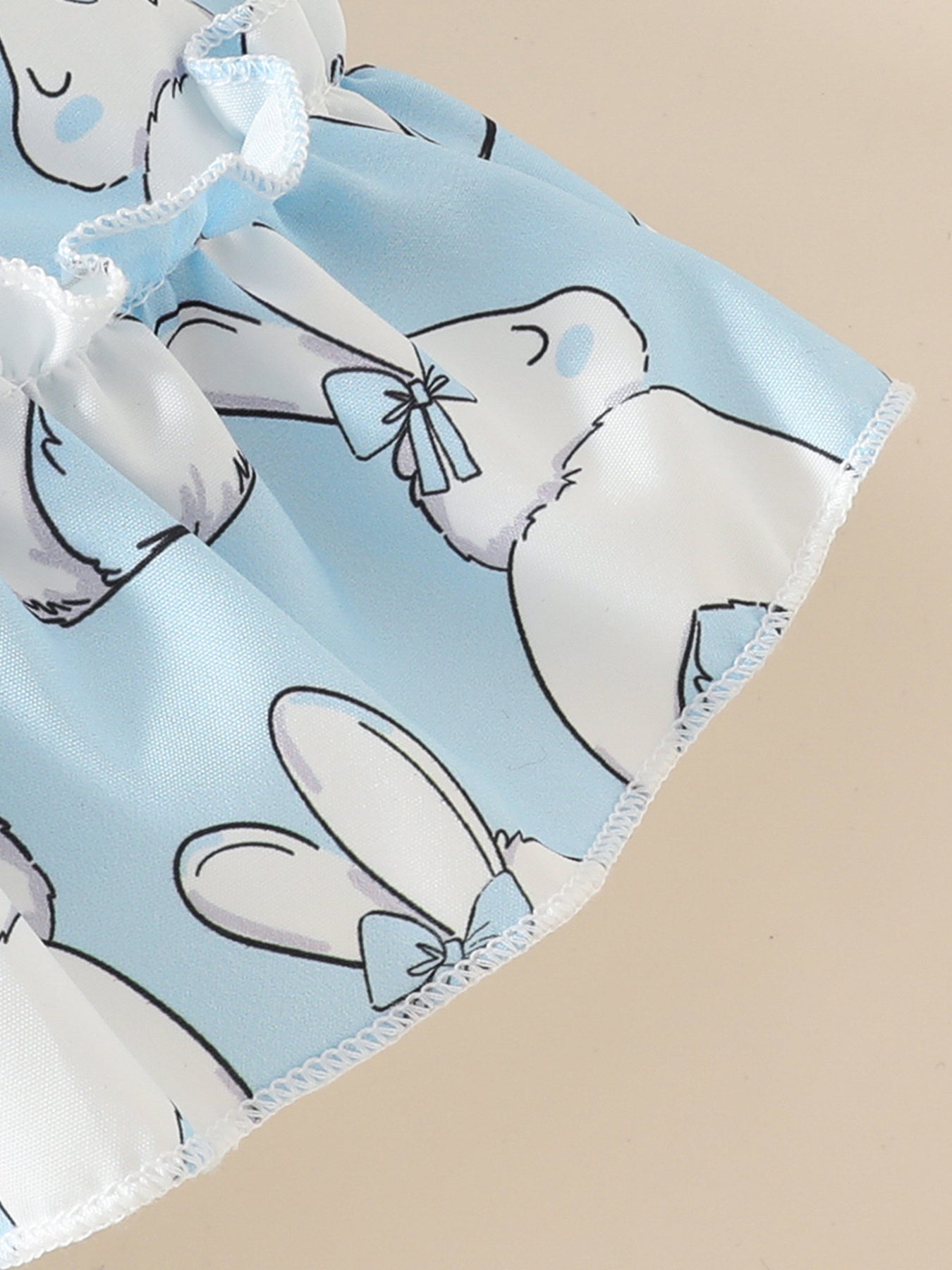Sky blue baby dress with white bunny print and ruffled trim.
