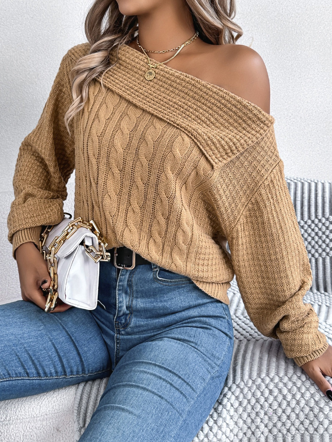 Camel off-shoulder cable knit pullover sweater with asymmetrical neckline and ribbed details.