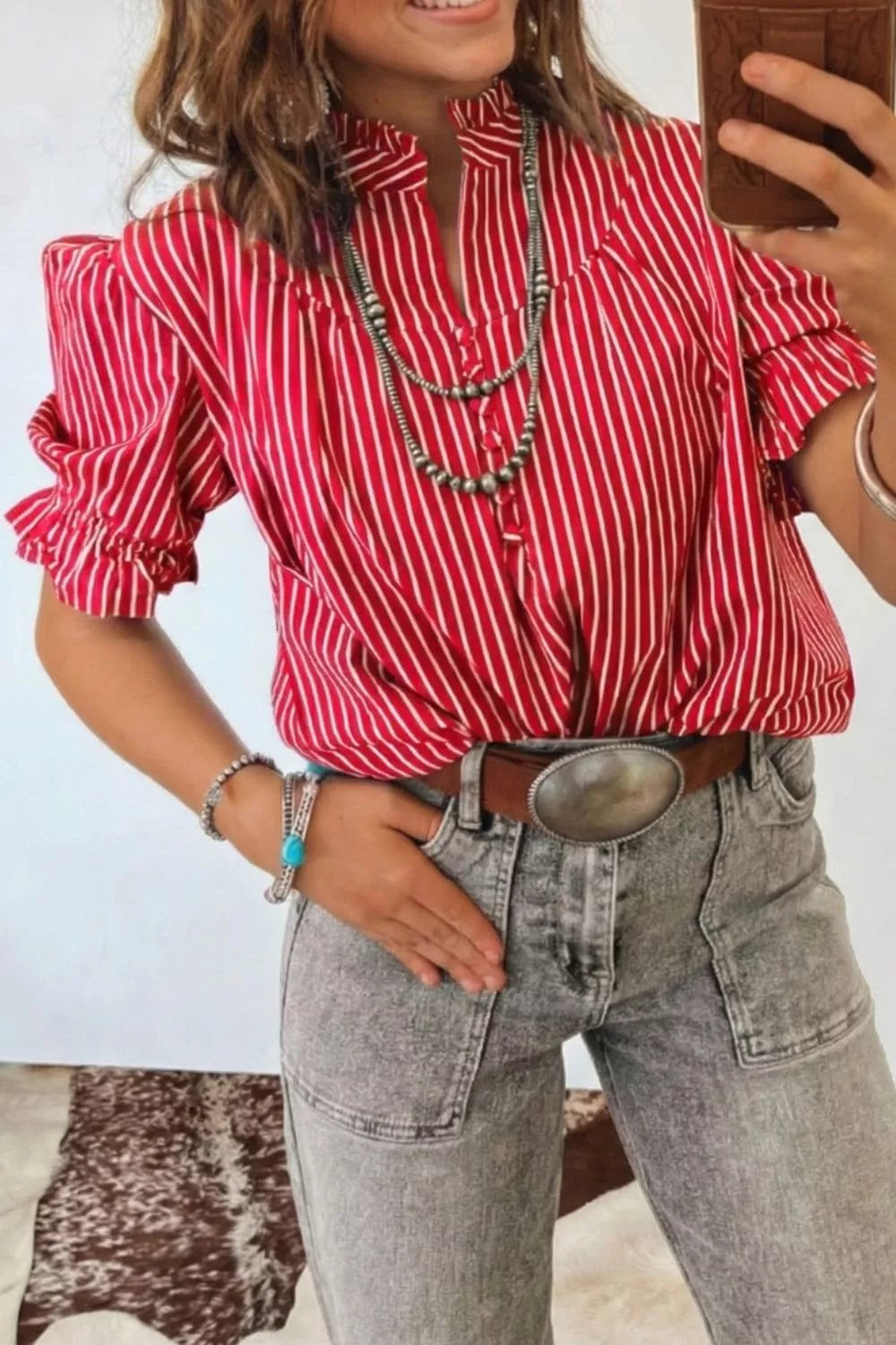 Red and white striped cotton shirt with ruffled sleeves and button front, styled with jewelry.