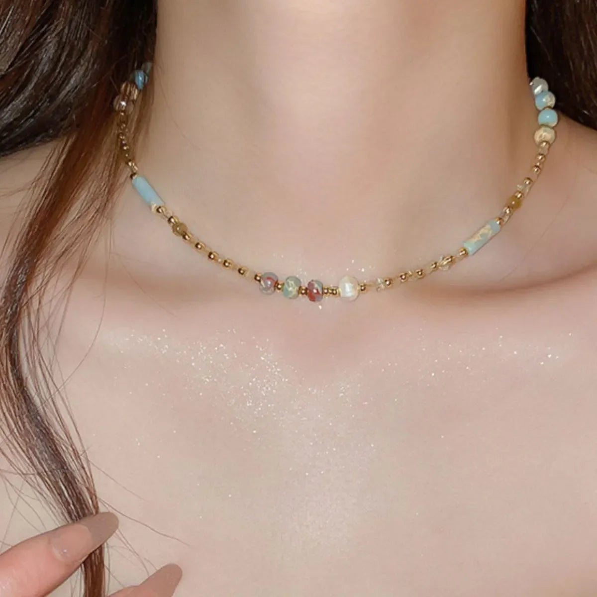 Multi-strand gemstone collar necklace with multicolor beads and light blue accents.