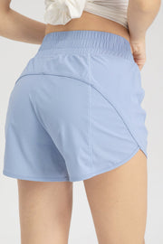 Light blue layered performance running shorts with elastic waistband and curved hem.