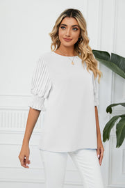 White blouse with pleated puff sleeves and smocked cuffs