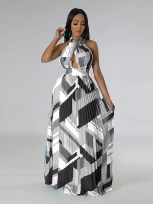 Halter neck maxi dress with geometric print, defined waistband, and pleated skirt.