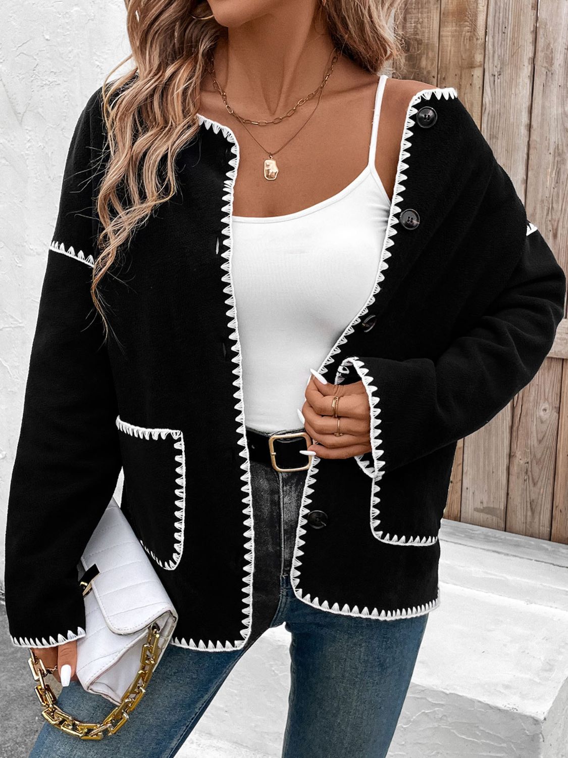 Black knit bolero jacket with white scalloped trim and button front.