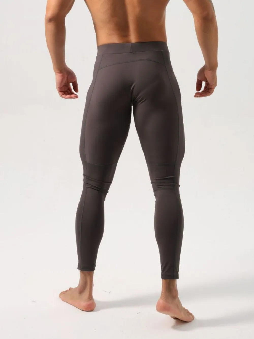 Men's dark gray athletic compression tights with a high waist and seam details.