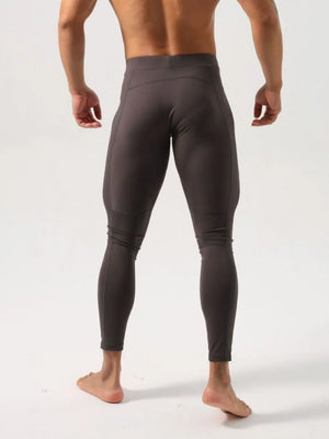 Men's dark gray athletic compression tights with a high waist and seam details.