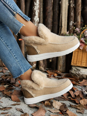 Beige felted slippers with shearling lining and stitch detail.